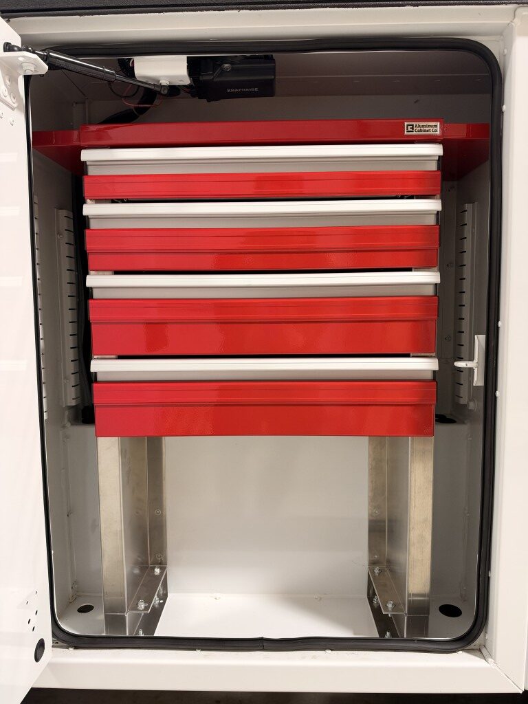Red four-drawer aluminum drawer unit installed in a Knapheide service body compartment